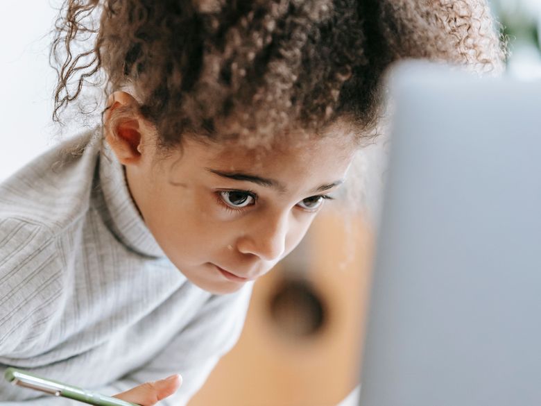 A child practising at home with a notebook and tablet